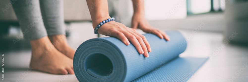 A person rolling out an exercise mat